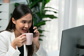 Working young Asian businesswoman calling to customer to present marketing online analysis service...