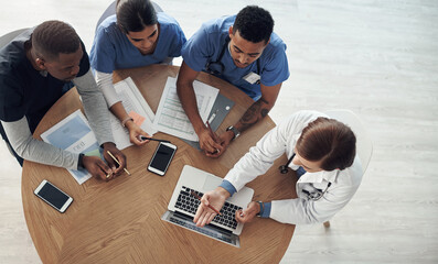 Doctor, teamwork and planning in meeting with paperwork, computer and training for medical residency in top view. Healthcare people, nurse and group leader with online research or solution for clinic