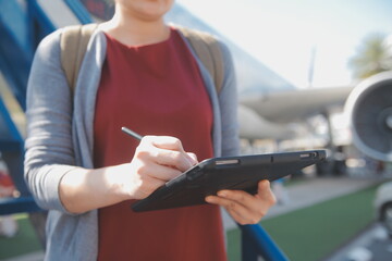 Blonde female tourist checking incoming notification on smartphone sitting on seat of airplane with...