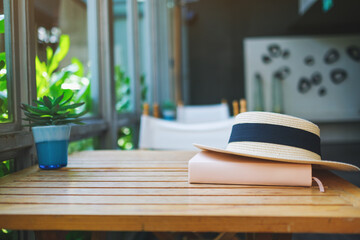 A hat and book on wooden table