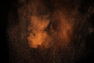 Brown fire grunge texture. Orange powder explosion on black background. Flame cloud. Yellow dust...