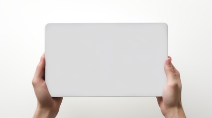 A person presenting a blank grey board against a white backdrop, hands gripping the edges