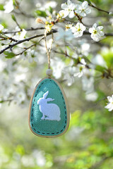 Decorative colored Easter egg with Easter bunny on a cherry blossom branch