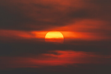 Evening sky time with sun and orange clouds in sunset sky background.Heat wave hot sun, climate change and global warming concept.