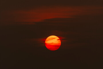 Evening sky time with sun and orange clouds in sunset sky background.Heat wave hot sun, climate...