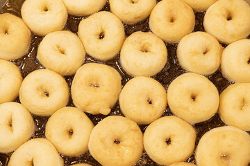 Mini donuts are fried in a pan with very hot oil.