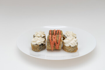Sushi rolls with sauce on a white plate