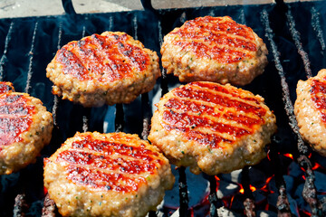 Burger patties grilled on the grill barbecue grate