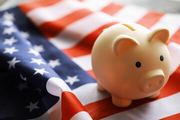 Closeup view of an American flag with a pink piggy bank for various financial concepts.