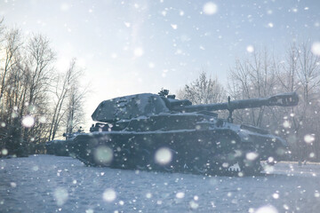 Military tank in a row. Battle tank in the snow on the roadside of highway. War in Ukraine in winter.