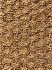 Close up of interwoven natural jute ropes creating textured pattern for rustic backgrounds and sustainable material concept.