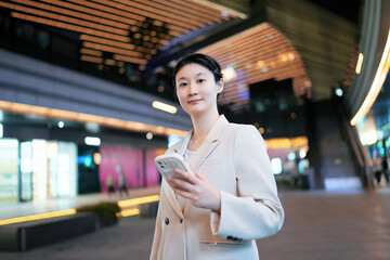 Businesswoman Using Smartphone in Modern City Setting