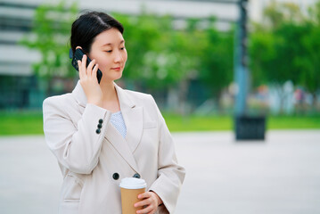 Professional Businesswoman Talking on Phone While Holding Coffee