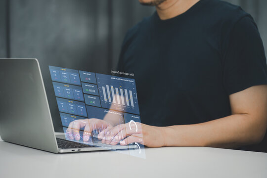 Professional analyzing complex data with a futuristic holographic display interface over a laptop, demonstrating cutting-edge technology in business analytics.