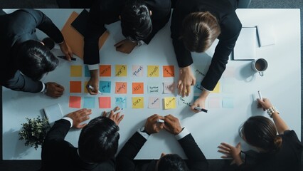 Top down aerial view of manager discuss and choose marketing idea from sticky notes. Group of...