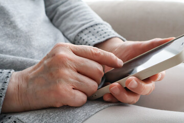 スマートフォンを操作するシニア女性の手元