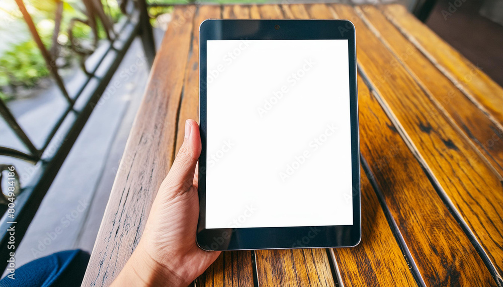 Poster mockup image of a hand holding digital tablet with blank white desktop screen
