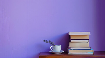 Table with books and cup near violet wall