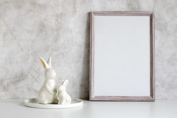 Easter mockup. empty wooden frame and rabbit figurines. background, an empty space for your text or...