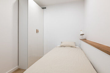 Soft bed with pillow and wardrobe in white color bedroom