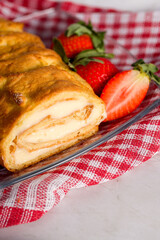 Sliced rolls with custard. The dessert is decorated with fresh strawberries