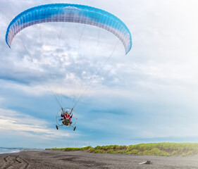 Paraglider flying over beach of Pacific ocean in Kanchatka