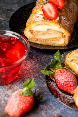 Sliced rolls with custard. The dessert is decorated with fresh strawberries