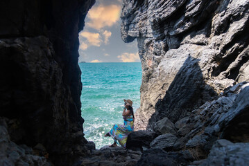 Travel people women tourist adventure in a cave near the sea. Travel Concept.
