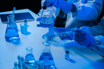 Medical or research scientist or doctor using looking at a test tube of clear solution in a lab or laboratory.