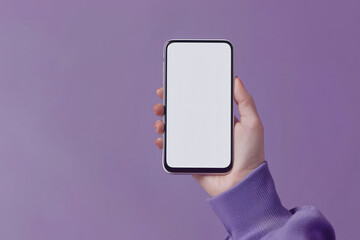 Woman's hand holding mobile phone with white empty screen in front of violet background