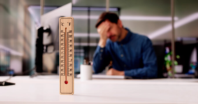 Thermometer In Front Of Businessman Working During Hot Weather