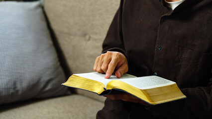 Man praying holding a Holy Bible. believe and pray bible concept.