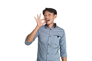A portrait of an Asian man wearing a light blue shirt, while making displaying the OK hand sign, isolated on a white background.