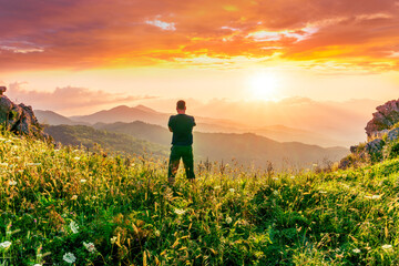 happy man watching amazing highland evening sunset, person delight with nature landscape