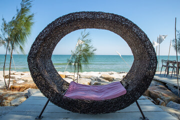 Fototapeta premium The wooden seat is shaped like a bird's nest with a beautiful sea view.