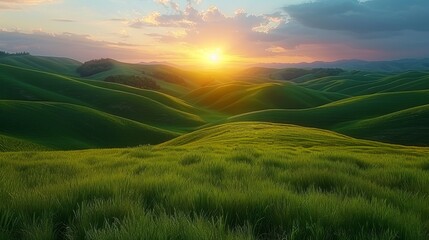 Fototapeta premium A lush field of green grass, sun sinking over distant hills, clouds painting the sky above
