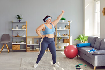 Overweight, obese woman doing physical exercises indoors at home. Plus size, fat young woman in...