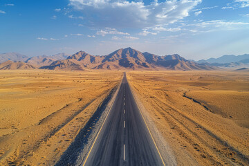 Drone view of a long straight road through a barren desert landscape. AI generated. - Powered by Adobe