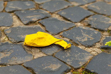 an old yellow balloon on a footpath