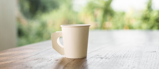 A paper coffee cup placed on a desk indoors, depicting a brief moment of pause or productivity....