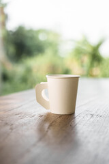 A paper coffee cup placed on a desk indoors, depicting a brief moment of pause or productivity. Workplace essentials, coffee break, and office culture converge.