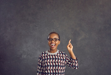 I have an idea. Young, energetic African-American woman raises her index finger as a sign that she...