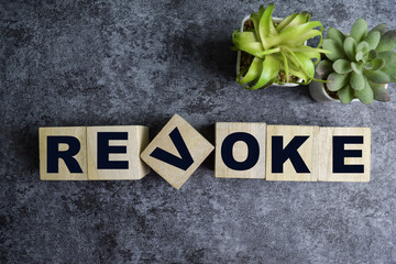 Concept of The wooden Cubes with the word Revoke on wooden background. - obrazy, fototapety, plakaty