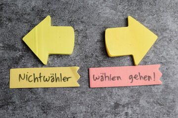 Concept of Nichtwahler und wahlen gehen write on sticky notes isolated on Wooden Table.