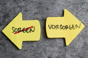 Concept of Sorgen un Vorsorgen write on sticky notes isolated on Wooden Table.