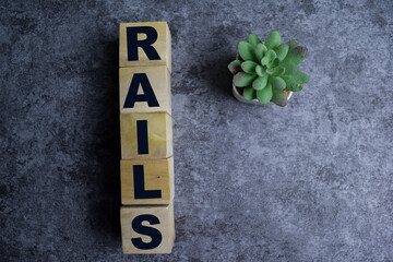 Concept of The wooden Cubes with the word Rails on wooden background.