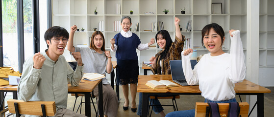 Happy university students and mature professor celebrating success in the classroom