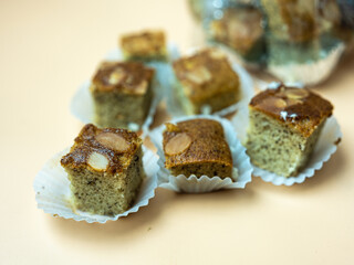 Mini square cut of sweet and soft banana cake served on paper cup. Selective focus. Close up.