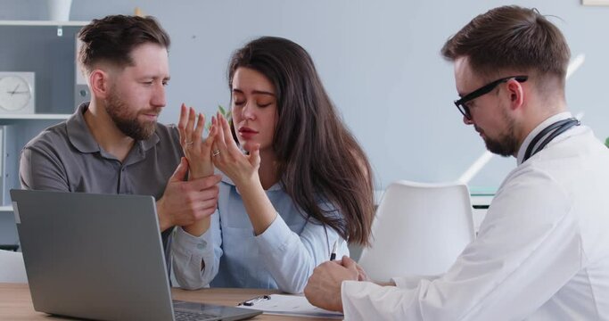 Young married couple in IVF doctors office trying to cope with failed infertility treatment. Supportive man calms down sad worried unhappy depressed woman after devastating examination checkup results