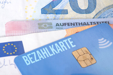 Ein Aufenthaltstitel für einen Flüchtling, Euro Geldscheine und eine Bezahlkarte